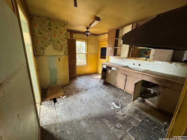 kitchen featuring tile countertops, backsplash, and ceiling fan