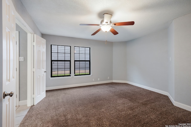 empty room featuring light carpet, a textured ceiling, and ceiling fan