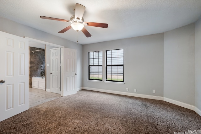 carpeted empty room with a textured ceiling and ceiling fan