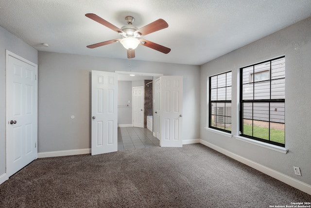 unfurnished bedroom with ceiling fan, a textured ceiling, and carpet floors