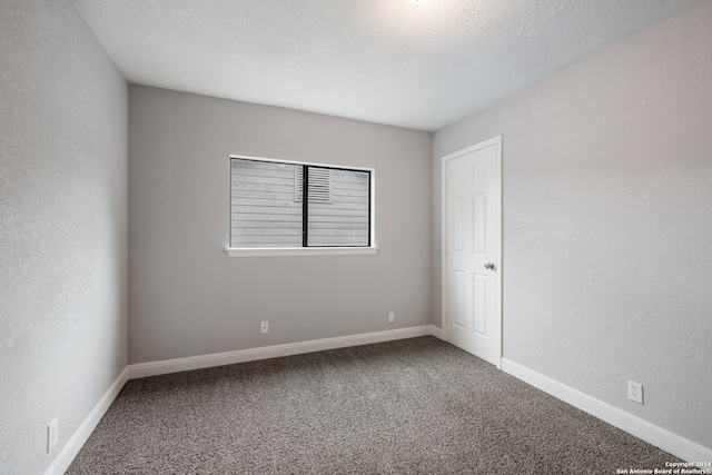 unfurnished room featuring a textured ceiling and carpet flooring