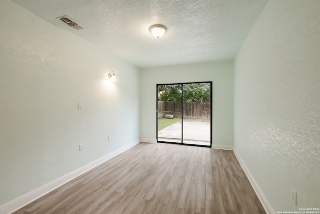 empty room featuring a textured ceiling and light wood-type flooring