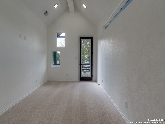 spare room with light colored carpet, beamed ceiling, and high vaulted ceiling