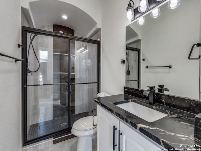 bathroom featuring vanity, tile patterned floors, toilet, and an enclosed shower