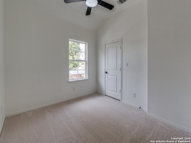 spare room with light carpet, vaulted ceiling, and ceiling fan