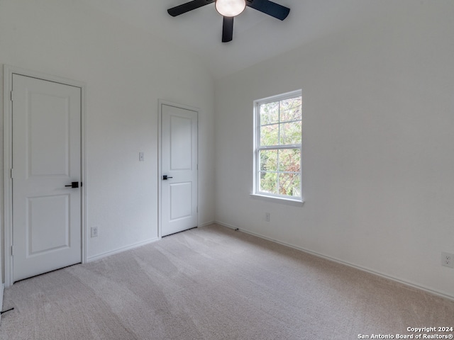 unfurnished room featuring lofted ceiling, light carpet, and ceiling fan