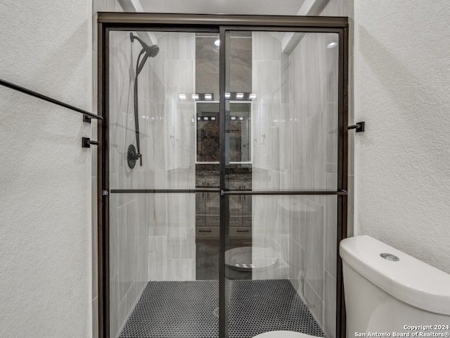 bathroom with toilet and an enclosed shower