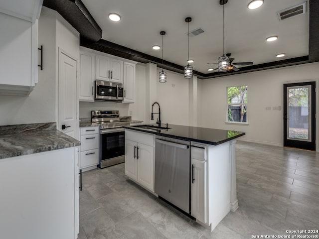 kitchen with appliances with stainless steel finishes, sink, hanging light fixtures, white cabinetry, and ceiling fan