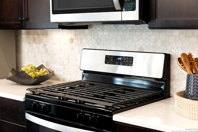 kitchen with range with gas stovetop, light countertops, dark brown cabinets, backsplash, and stainless steel microwave