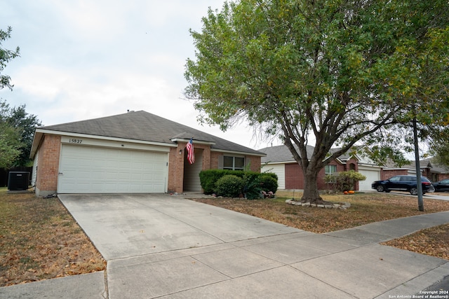 ranch-style home featuring central AC and a garage