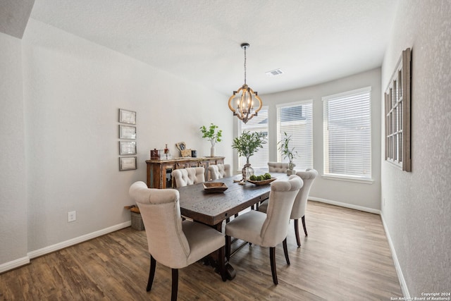 dining space with a notable chandelier and wood-type flooring