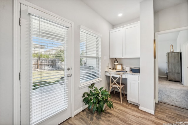 entryway with built in desk and light hardwood / wood-style floors