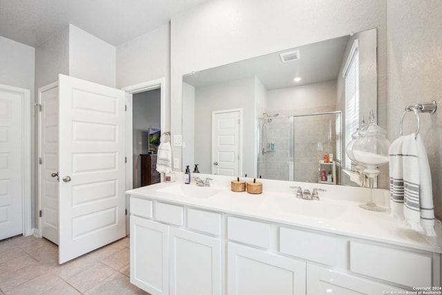 bathroom with vanity, walk in shower, and tile patterned flooring