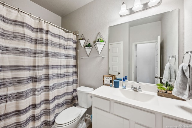 bathroom with toilet, a textured ceiling, curtained shower, and vanity