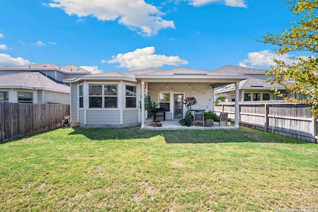 rear view of house featuring a patio area, a lawn, and ceiling fan