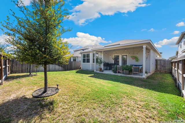 back of house featuring a patio and a lawn