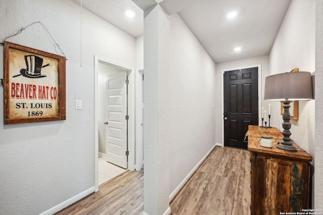 hallway with light hardwood / wood-style floors