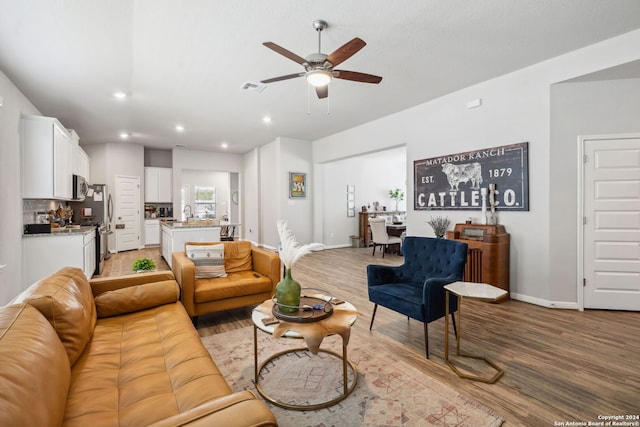 living room featuring light wood-type flooring and ceiling fan