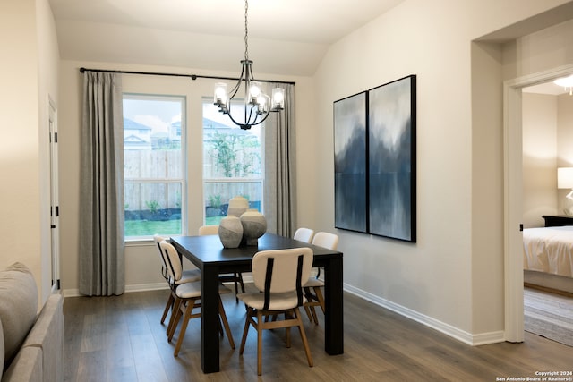 dining room featuring a chandelier, dark wood-type flooring, and vaulted ceiling