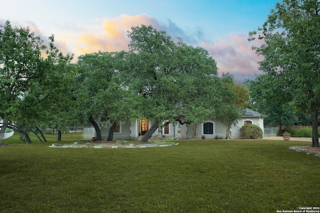 obstructed view of property with a yard