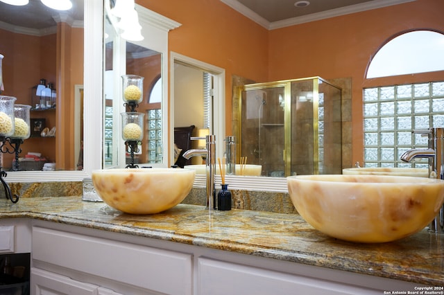 bathroom featuring a shower with door, vanity, and ornamental molding