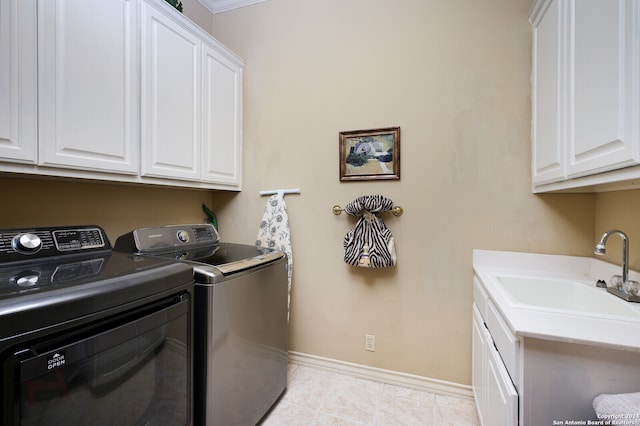 laundry room featuring sink, light tile patterned flooring, separate washer and dryer, and cabinets