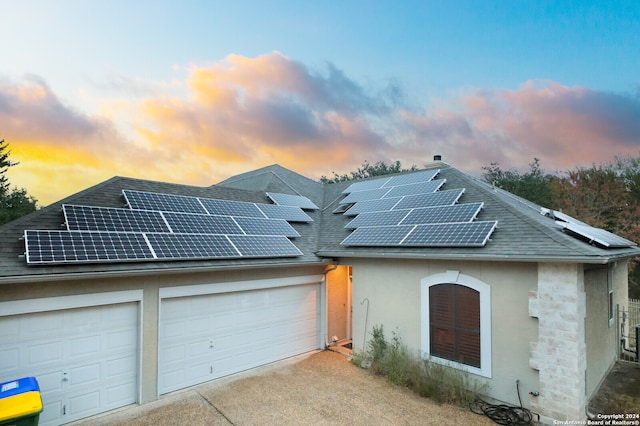 view of front of property with a garage and solar panels