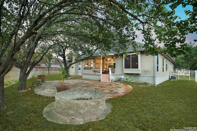 view of front facade featuring a front yard, central air condition unit, and a patio