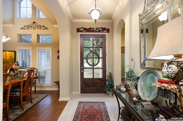 entrance foyer with ornamental molding and hardwood / wood-style floors