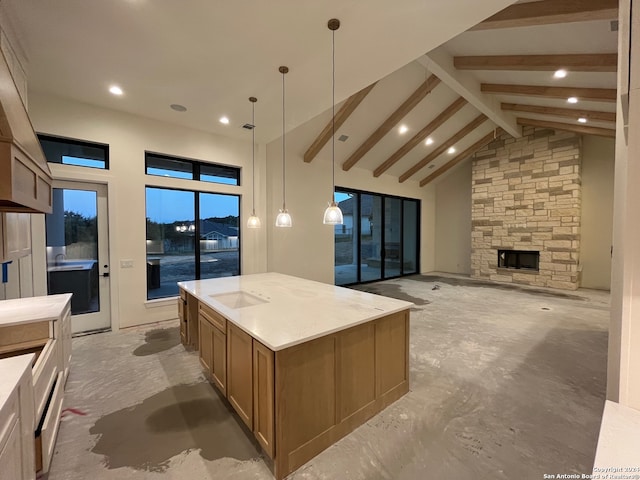 kitchen featuring a kitchen island, high vaulted ceiling, sink, hanging light fixtures, and beam ceiling