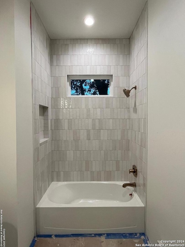 bathroom featuring tiled shower / bath