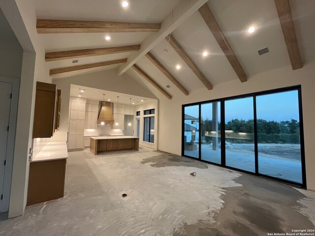 unfurnished living room with beamed ceiling and high vaulted ceiling