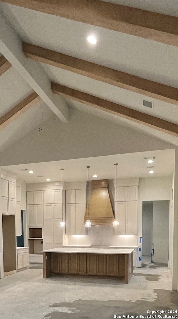 kitchen with a spacious island, hanging light fixtures, custom range hood, and white cabinets