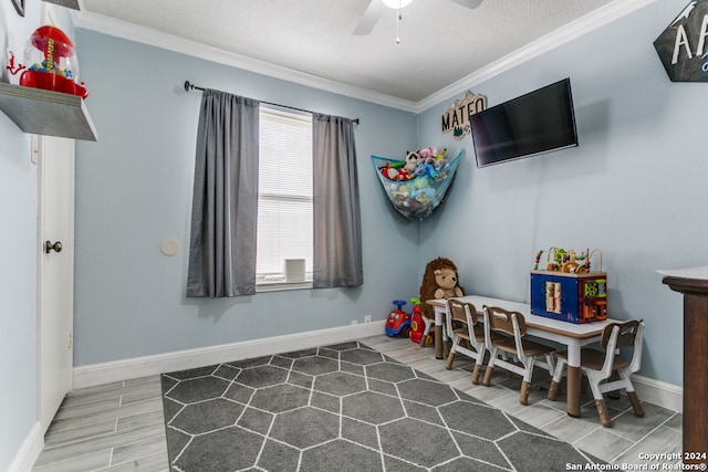 game room featuring crown molding, hardwood / wood-style floors, a textured ceiling, and ceiling fan