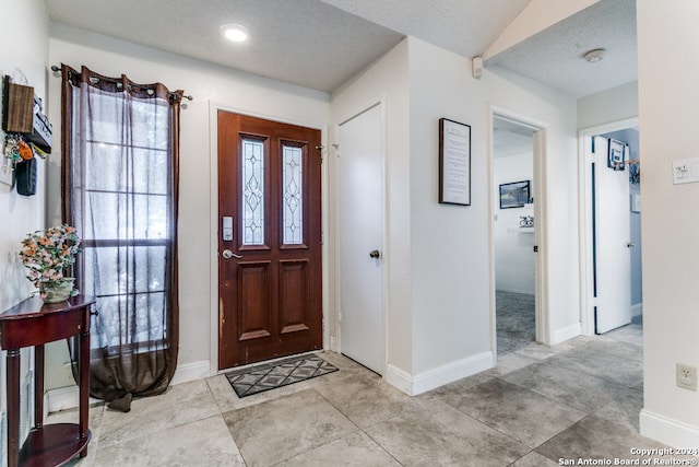 tiled foyer entrance with a textured ceiling