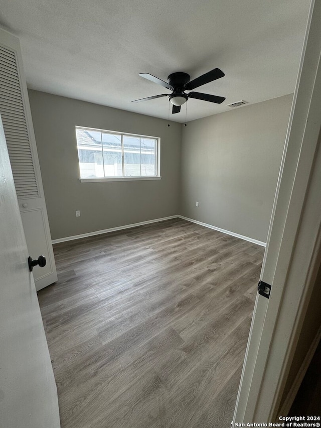 empty room featuring a textured ceiling, hardwood / wood-style flooring, and ceiling fan