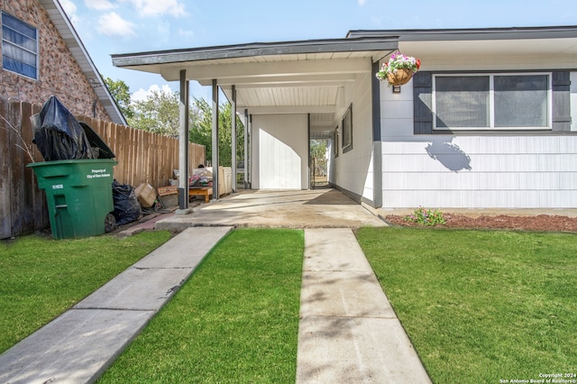 property entrance featuring a yard and a carport