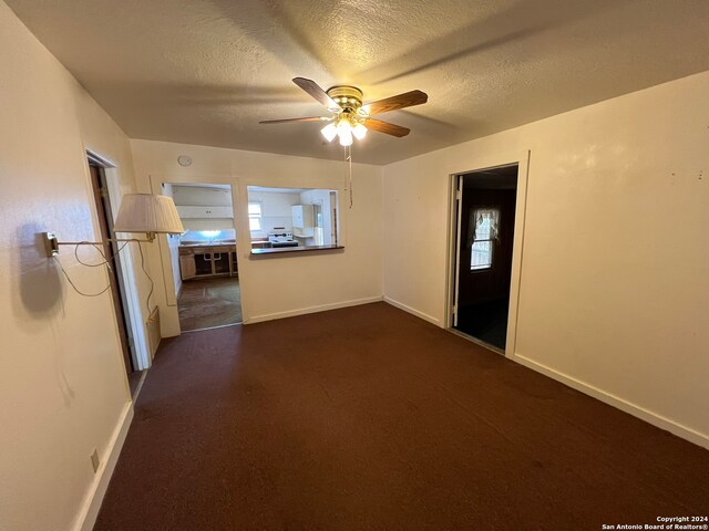 unfurnished room featuring ceiling fan and a textured ceiling