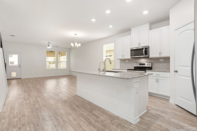 kitchen featuring a healthy amount of sunlight, appliances with stainless steel finishes, sink, and a center island with sink