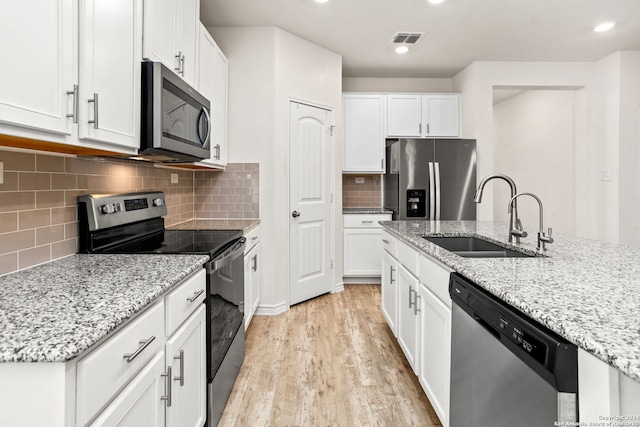 kitchen featuring sink, white cabinetry, stainless steel appliances, and light wood-type flooring