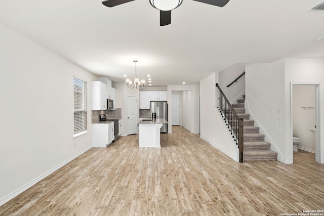 unfurnished living room featuring sink, light hardwood / wood-style flooring, and ceiling fan with notable chandelier