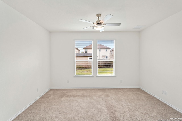 unfurnished room featuring light colored carpet and ceiling fan