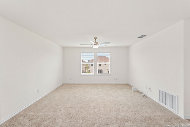 spare room featuring light colored carpet and ceiling fan