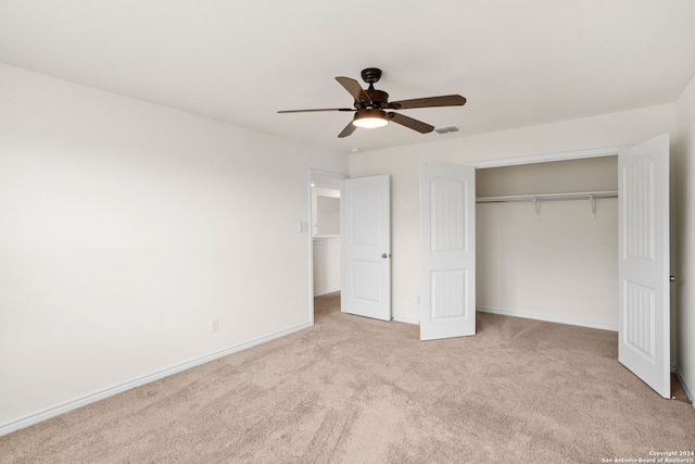 unfurnished bedroom with light carpet, a closet, and ceiling fan