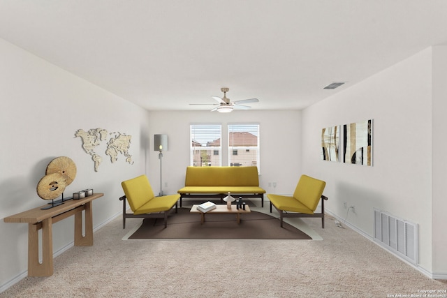 living area with light carpet and ceiling fan