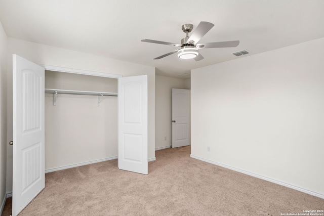 unfurnished bedroom featuring a closet, ceiling fan, and light colored carpet