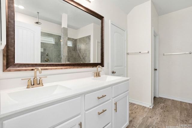 bathroom featuring vanity, hardwood / wood-style flooring, and tiled shower