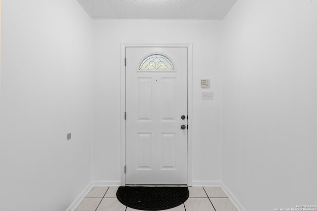 tiled entryway with a textured ceiling