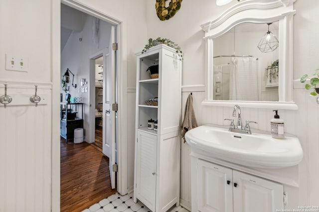 bathroom with vanity, vaulted ceiling, and wood-type flooring