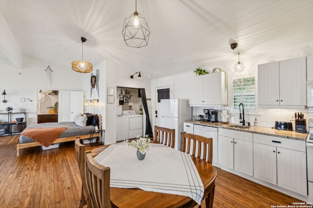 dining room with hardwood / wood-style floors, lofted ceiling, sink, and washing machine and dryer